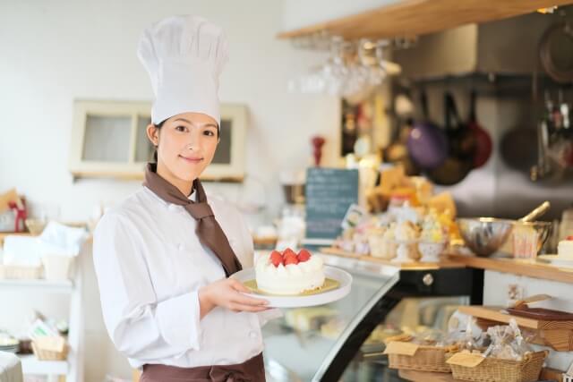 ケーキを持ったパティシエの写真